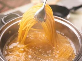 rauwe spaghetti wordt gekookt in kokend water