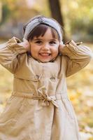 het meisje sluit haar oren met haar vingers in het herfstpark. foto