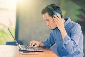 man aan het werk computer luisteren muziek in café, freelancer werk in café foto