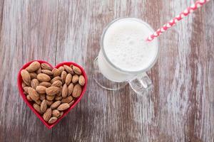 amandelen in hartvormige kom met melk van bovenaf foto