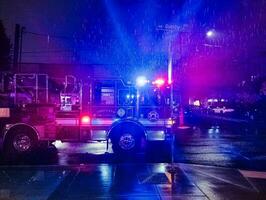 Portland, Oregon, Verenigde Staten van Amerika - 11.02.2023 brand vrachtauto met knippert lichten Bij nacht, gebeld naar een brand alarm in de plaatstad Oppervlakte. regen. foto