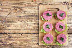 sandwiches met slablaadjes en gesneden salami worst op een houten bord. bovenaanzicht kopieerruimte foto