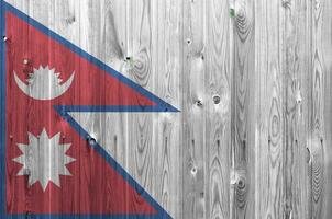 Nepal vlag afgebeeld in helder verf kleuren Aan oud houten muur. getextureerde banier Aan ruw achtergrond foto