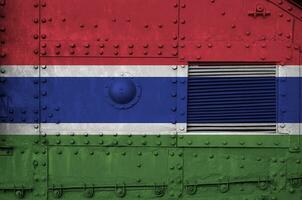 Gambia vlag afgebeeld Aan kant een deel van leger gepantserd tank detailopname. leger krachten conceptuele achtergrond foto