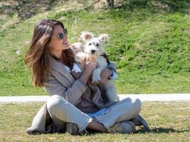 jonge vrouw die tijd doorbrengt met haar witte schnauzerpuppy. foto