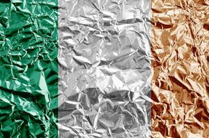 Ierland vlag afgebeeld in verf kleuren Aan glimmend verfrommeld aluminium folie detailopname. getextureerde banier Aan ruw achtergrond foto