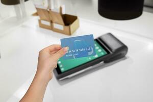 beveiligen kaart betaling Bij strak pos terminal. hand- Holding credit kaart voor transactie. veilig, handig betaling werkwijze foto