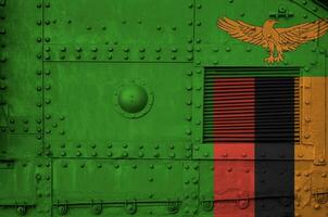 Zambia vlag afgebeeld Aan kant een deel van leger gepantserd tank detailopname. leger krachten conceptuele achtergrond foto