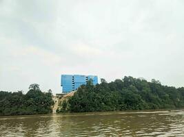 visie van de gebouw Aan de rivier- bank en omringd door bomen foto