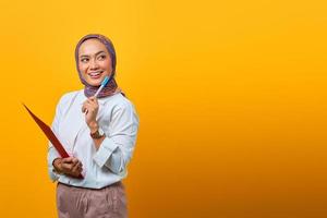 mooie aziatische vrouw met mappen en pen die naar de zijkant kijkt foto