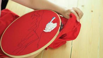 vrouwenhanden en ambachtelijk werk. borduur naaien met de hand. foto