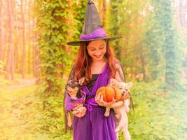 heks met een pompoen. kind meisje in heks kostuum buitenshuis. foto