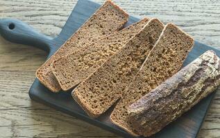 plakjes van rogge brood Aan de houten bord foto