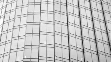 glas modern gebouw met blauw lucht achtergrond. visie en architectuur details. stedelijk abstract - ramen van glas kantoor gebouw in zonlicht dag. zwart en wit. foto