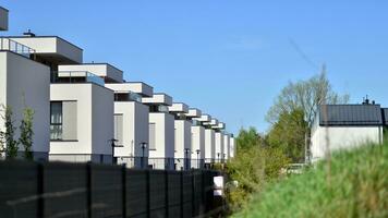 buitenwijk buurt met condominium complex. buitenwijk Oppervlakte met modern meetkundig familie huizen. rij van familie huizen tegen blauw lucht. foto