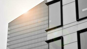 glas modern gebouw met blauw lucht achtergrond. visie en architectuur details. stedelijk abstract - ramen van glas kantoor gebouw in zonlicht dag. zwart en wit. foto