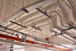 sanitair systeem pijpen en elektrisch kabels geïnstalleerd onder vlak plaat versterkt beton structuur in gebouw. foto