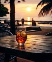 glas van aperol spritz cocktail Aan houten tafel met zonsondergang vervagen strand achtergrond ai generatief foto