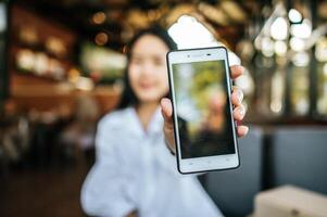 smartphone met vrouw met linkerhand in café foto