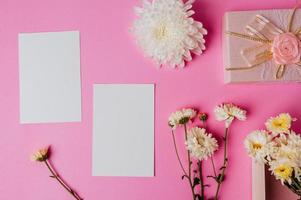 roze geschenkdoos, bloem en blanco kaart op roze achtergrond foto
