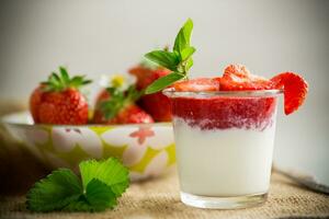 zoet eigengemaakt yoghurt met aardbei jam en vers aardbeien in een glas kop foto