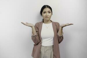 een Aziatisch vrouw werknemer vervelend een Cardigan looks zo verward tussen keuzes, geïsoleerd door een wit achtergrond foto