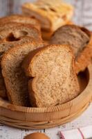 sneetjes brood geplaatst in een houten bord op een witte houten tafel. foto