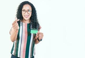 gelukkig afro meisje in bril Holding credit kaart maken geld gebaar met vingers, op zoek Bij camera geïsoleerd foto