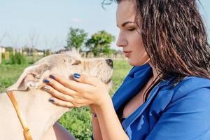 jonge aantrekkelijke vrouw speelt met haar hond in het park foto