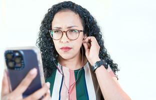 jong afro vrouw luisteren naar muziek- met hoofdtelefoons geïsoleerd. dichtbij omhoog van afro meisje luisteren liedjes met mobiele telefoon Aan geïsoleerd achtergrond foto