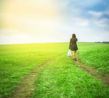 vrouw wandelen in de veld- met boodschappen doen Tassen, vrouw wandelen Aan een weg in de veld- foto