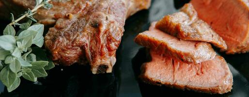 rundvlees steaks Aan een zwart bord met groenen. foto