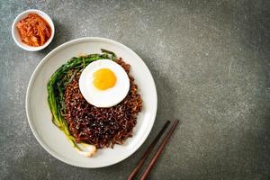 gedroogde Koreaanse pittige zwarte saus instant noedels met gebakken ei foto