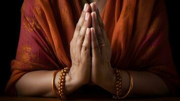 bidden handen met oranje kralen Aan donker houten oppervlakte foto