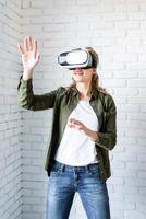 vrouw in vr-bril staande op witte bakstenen muur achtergrond foto