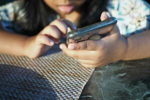 kind meisje aan het kijken tekenfilm Aan slim telefoon foto