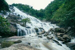 mooi waterval in weelderig tropisch groen Woud. natuur landschap. mae ja waterval is gelegen in doi inthanon nationaal park, Chiang mei, Thailand. waterval stromen door oerwoud Aan berghelling. foto