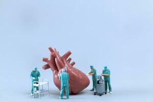 miniatuur mensen dokter controle en analyse hart model- , wetenschap en geneeskunde concept foto