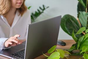 vrouwen handen Bij een laptop tegen een achtergrond van groen. foto