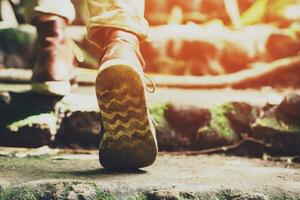 wandelen spoor pad in actie Aan een bergen of Woud met wandelen schoenen. mannetje wandelaars schoenen. zijn wandelen door Woud pad vervelend berg laarzen en wandelen. bestemming beleven. mos. steen. steen foto