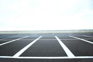 leeg buitenshuis parkeren veel ruimte gemarkeerd met wit lijnen. kan accommoderen auto een kavel. foto