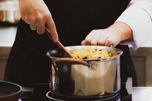 chef-kok bereidt eten, maaltijd, in de keuken, chef-kok koken foto