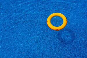 top visie van reddingsboei drijvend in blauw zwemmen zwembad, zacht focus. foto