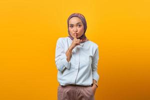 mooie aziatische vrouw die vinger op lippen maakt mond stil stil gebaar foto