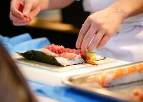 chef-kok handen die Japans eten bereiden, chef-kok die sushi maakt foto