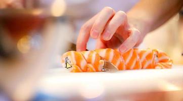 chef-kok handen die Japans eten bereiden, chef-kok die sushi maakt foto