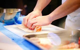 chef-kok handen die Japans eten bereiden, chef-kok die sushi maakt foto