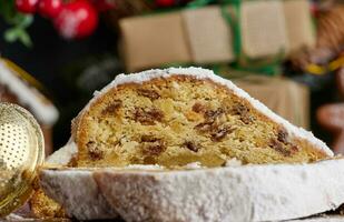 Kerstmis gebakjes stollen besprenkeld met gepoederd suiker Aan de tafel, feestelijk toetje foto