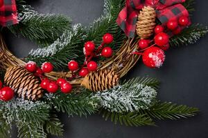 een circulaire Kerstmis krans gemaakt van Spar takken en andere decoraties Aan een zwart schoolbord foto