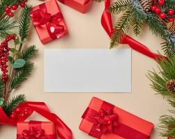 Kerstmis decor, cadeaus verpakt in rood papier en een brief Aan een beige achtergrond foto